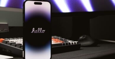 a cell phone sitting on top of a desk next to a keyboard